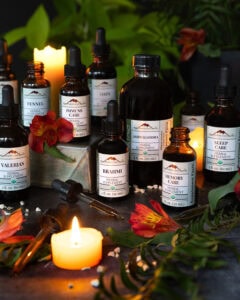 Mountain Rose Herbs organic herbal tincture bottles with dropper tops and candles, promoting their spring extract sale.